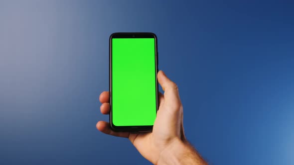 A Young Man with a Modern Smartphone in His Hand Looking at a Mockup Screen with Tracking Markers on alt