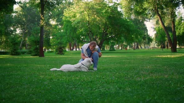 Smiling Retriever Owner Sit in Squats Petting alt