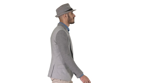 Casual arabic man in hat walking on white background. alt