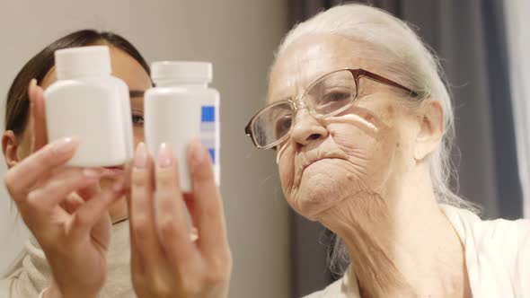 Female Volunteer Reading Prescription on Drugs to Old Woman