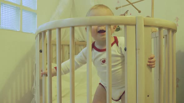 Baby boy playing in crib