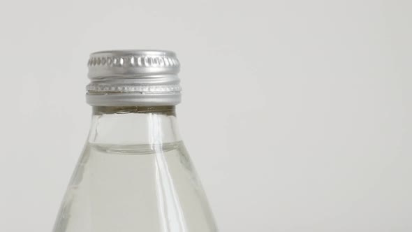 Transparent bottle of water on white 4K tilting video