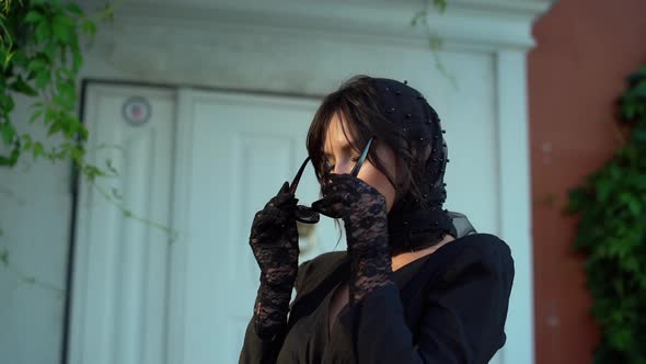 Pretty European Girl in Black Dress and Headscarf Walks Through Streets of the City alt