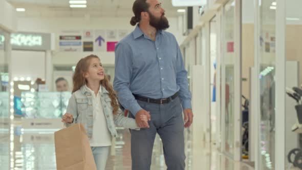 Loving Father Walking at Shopping Mall with His Adorable Little Daughter alt