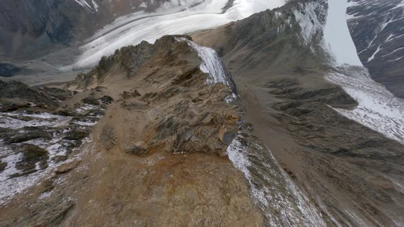 Aerial View Fast Dive Movement From Cliff Peak on Wide Stone Ridge Between Rocks alt