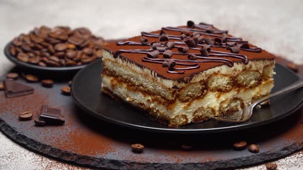 Portion of Traditional Italian Tiramisu dessert on grey concrete background alt