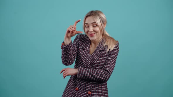 The Blonde Amused By Her Blond Hair Shows with Her Hand the Gesture of a Small Size and Displays alt