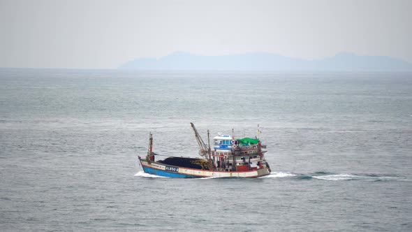 Fishing Boat Sails Into the Sea for Seafood on A Cloudy Day alt