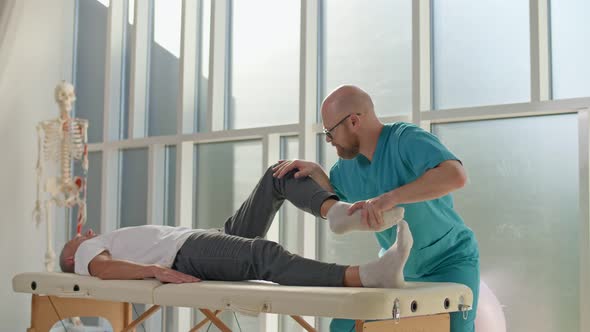 Physiotherapist Conducting a Therapy Session With an Older Man in a Rehabilitation Center. alt