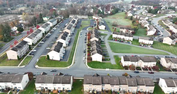 Aerial truck shot of townhouse homes in USA neighborhood in barren autumn fall landscape. alt