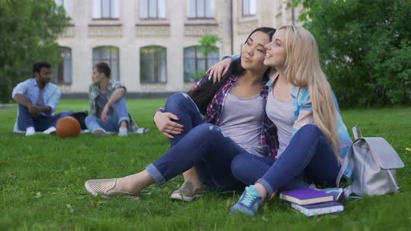 Best Friends Sitting on Lawn Near College and Talking, Support and Friendship alt
