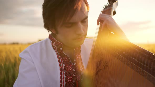 Close Up of Handsome Man Musician Bandurist Playing on Lyrical Bandura Ukrainian Traditional