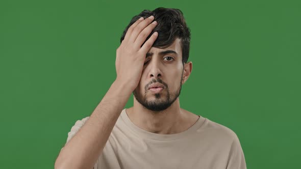 Male Portrait of Arabic Indian Disappointed Guy Upset Stressful Man Stand in Green Studio Cover Face alt