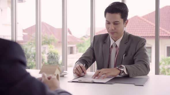 Smart handsome Businessmen signing a house contract alt