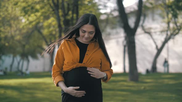 Pregnant Happy Woman outdoors enjoying nature. Mom Expecting her Baby.