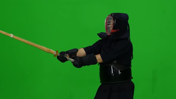 Masculine Kendo Warrior Practicing Martial Art with the Bamboo Bokken on Green Screen. CLose Up alt