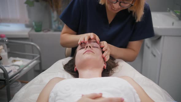 Massage Session  Young Woman Performs Acupressure on His Client's Face alt