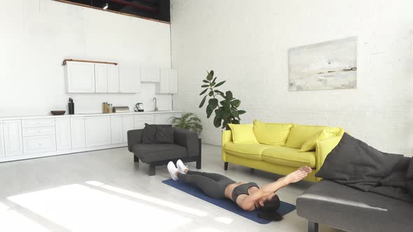 Beautiful Young Woman Doing Exercises on the Floor at Home alt