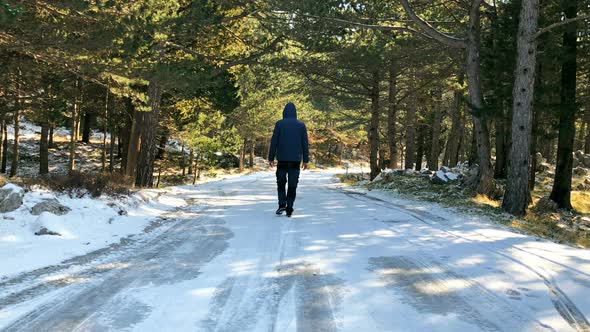 Man Walking On The Middle Of Frozen Road At Mountain