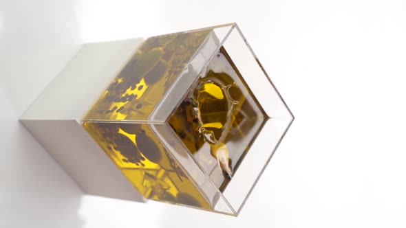 Vertical video: garlic falling into olive oil alt