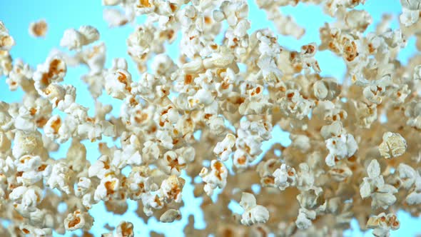 Super Slow Motion Shot of Popcorn on Blue Background After Being Exploded at 1000Fps. alt