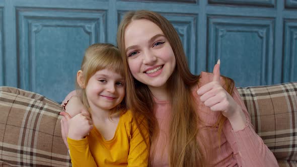 Portrait of Satisfied Child Kid Daughter with Young Mother Hugging Embracing Showing Thumbs Up alt