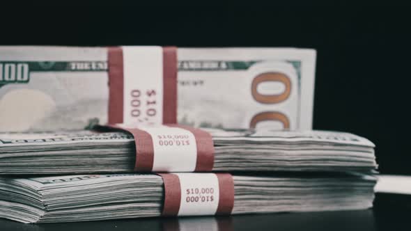 Bundles of Dollars Rotate on Black Background alt