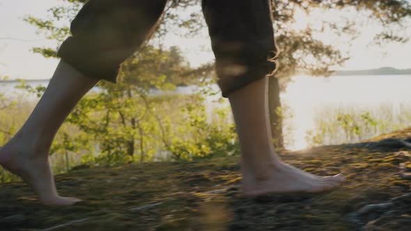 Legs of Man Walking on Forest Path Near River Closeup alt