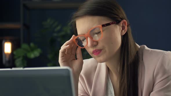Close Up Portrait of a Beautiful Serious Woman in Glasses Working at a Laptop