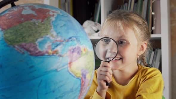 Girl with a Magnifying Glass and a Globe