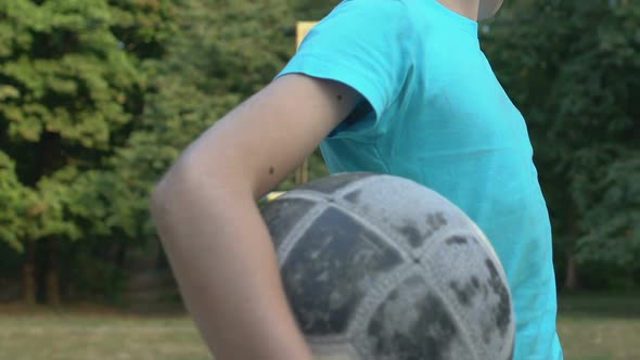 Upset Little Boy Holding Ball Feeling Lonely at Sport Field, Looking for Friends