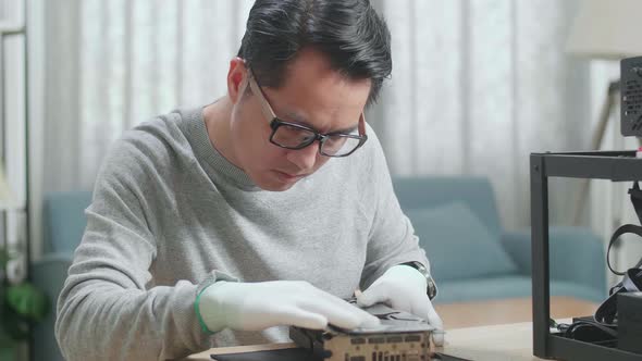 Close Up Of Asian Man Wearing Glasses Wiping The Mining Rig For Mining Cryptocurrency alt