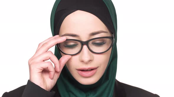 Portrait of Gorgeous Arabic Woman in Traditional Scarf and Eyeglasses Posing on Camera with Charming alt