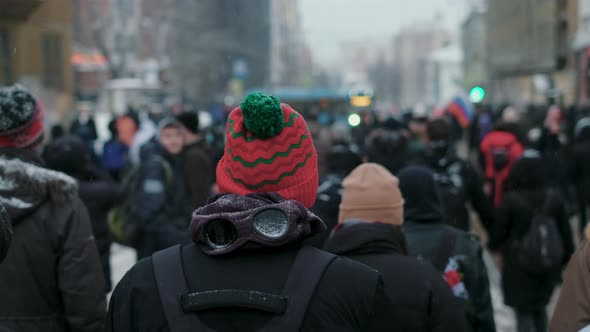 Casually Looking Protester in Red Winter Hat Marching Along with Rally Activist