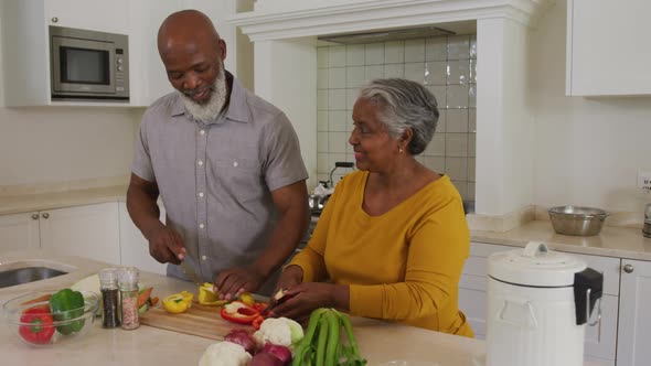 African American Senior Couple Chopping Vegetables Together In The 