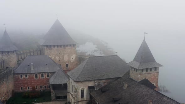Aerial view of the old castle in foggy weather - tilt up drone shot. alt