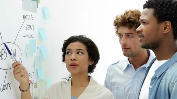 Attractive young creative designer talking to her colleagues alt