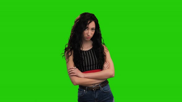 Beautiful Caucasian girl with long curly dark hair posing on green screen alt