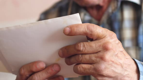  in the wrinkled hands of an elderly man old family photos. a pensioner examines a photo, nostalgia  alt