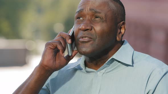 Black Adult Mature African American Man Consultant Sitting Outdoors Holding Smartphone in Hand alt