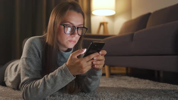 Woman Glasses Is Lying Floor Using Smartphone Evening alt