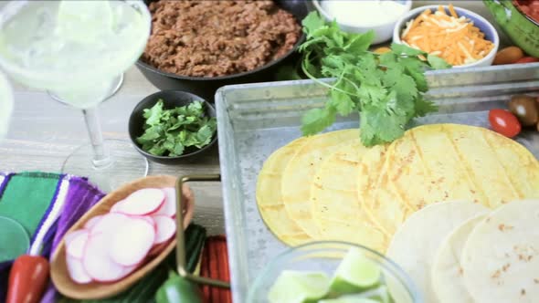 Ground beef tacos with romaine lettuce, diced tomatoes, radishes, and shredded cheddar cheese. alt