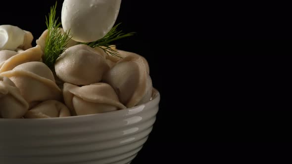 Sour Cream is Added to a Plate of Dumplings alt