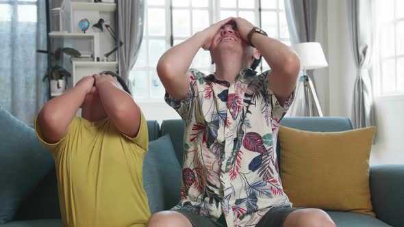 Frustrated Disappointed Asian Father And His Son Are Watching Tv alt
