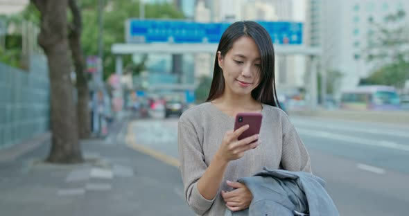 Woman use of mobile phone in city alt