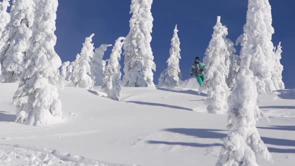 A man skiing down a snow-covered mountain in the winter. alt