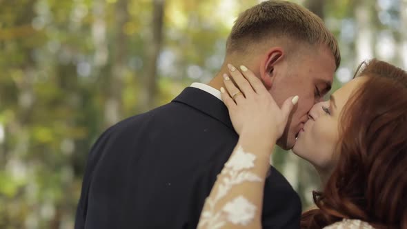 Groom with Bride in the Forest Park. Wedding Couple. Making a Kiss alt