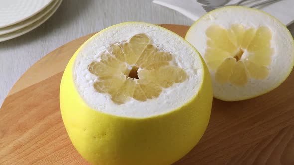 Fresh large yellow pomelo with a cut from the top  alt
