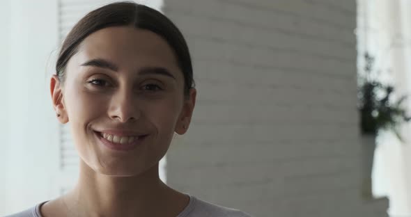 A Young Female Freelancer Designer Looks Confidently Into the Camera and Smiles alt