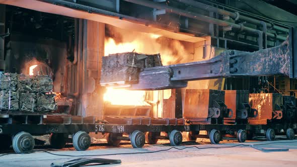 Industrial Mechanism is Transporting Copper Materials Into a Furnace alt